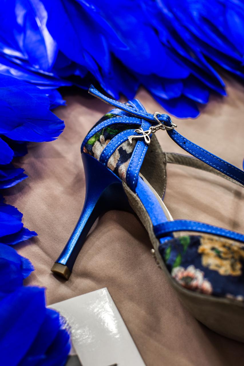 Naos Tanzschuhe in Blau geblümt von Dancing Queens auf beigem Untergrund mit leuchtend blauen Federn.